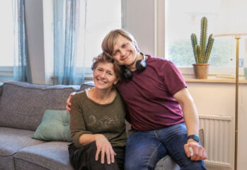 kvinna i soffa ung man på soffkanten med armar om varandra