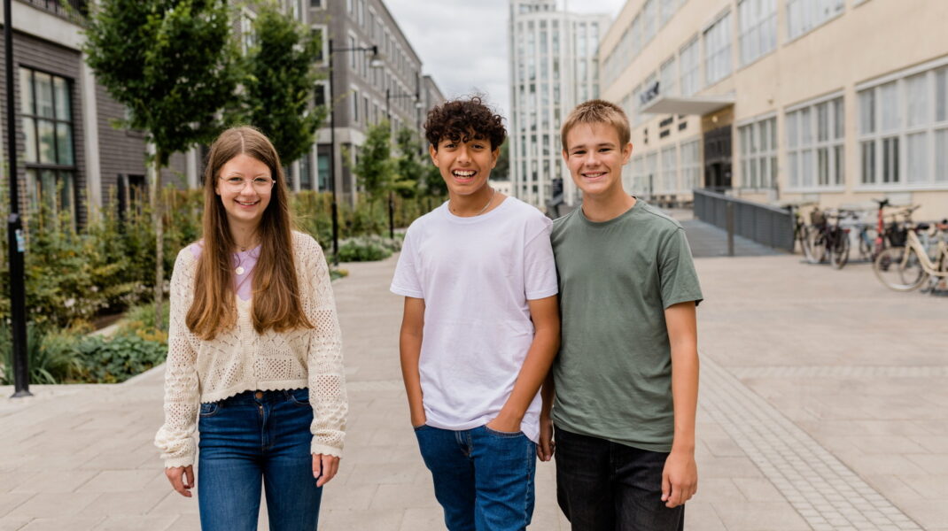 Tre ungdomar på en skolgård