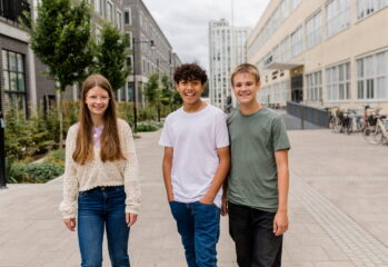 Tre ungdomar på en skolgård