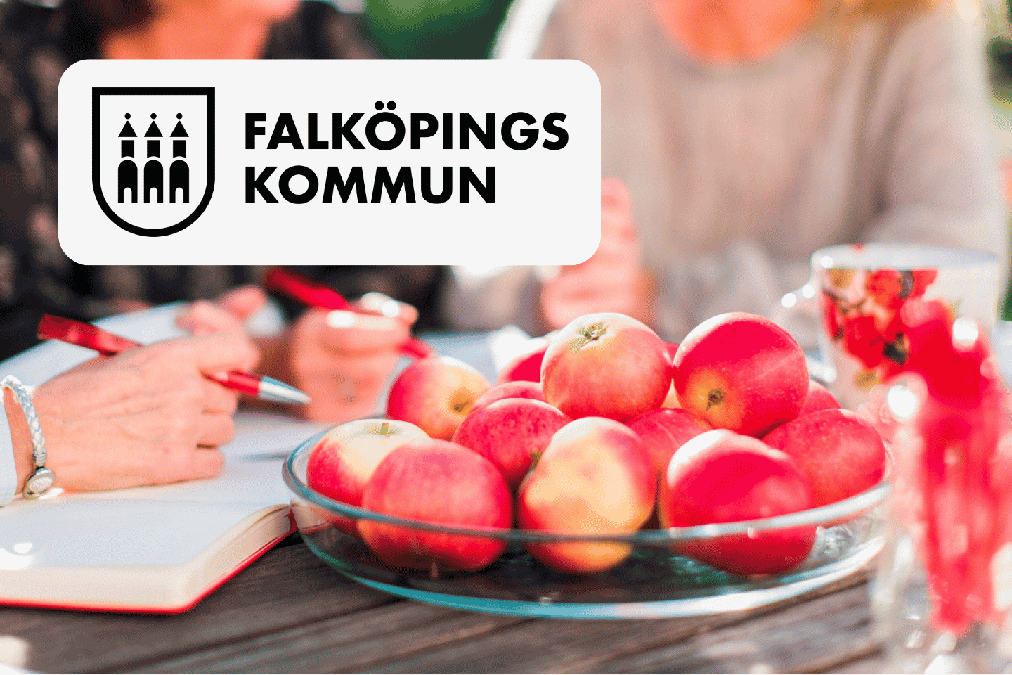 Falköpings kommun logga med äpplen på ett bord