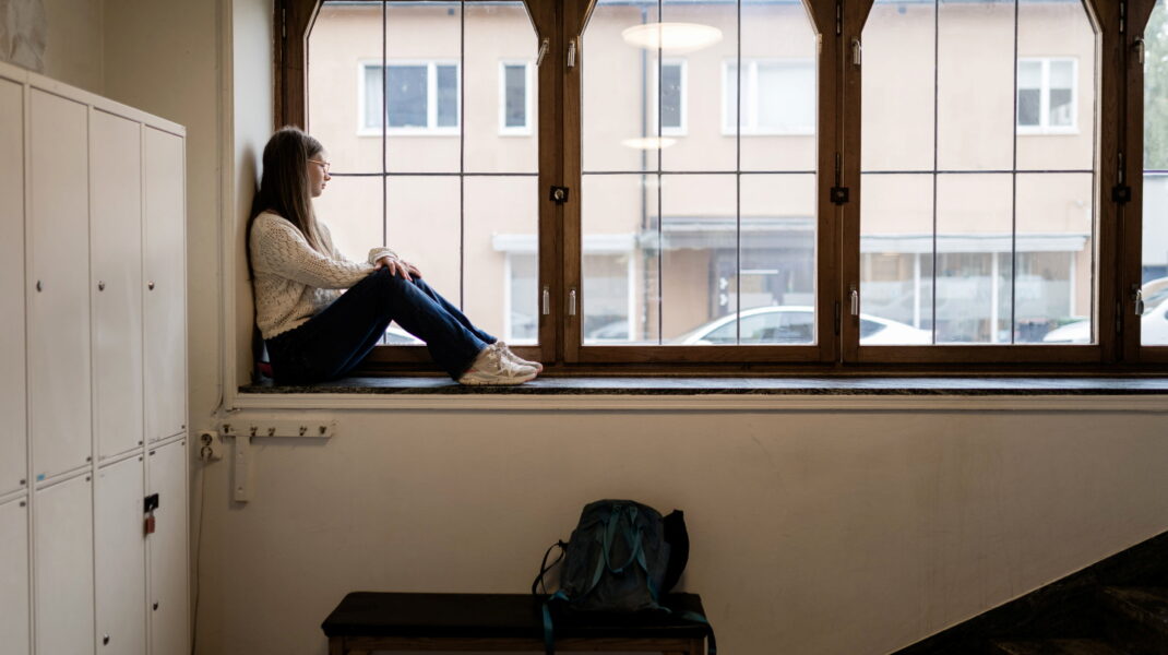 Tjej sitter i fönster på skola
