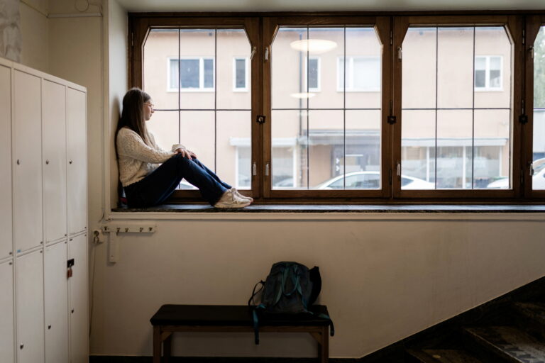Tjej sitter i fönster på skola